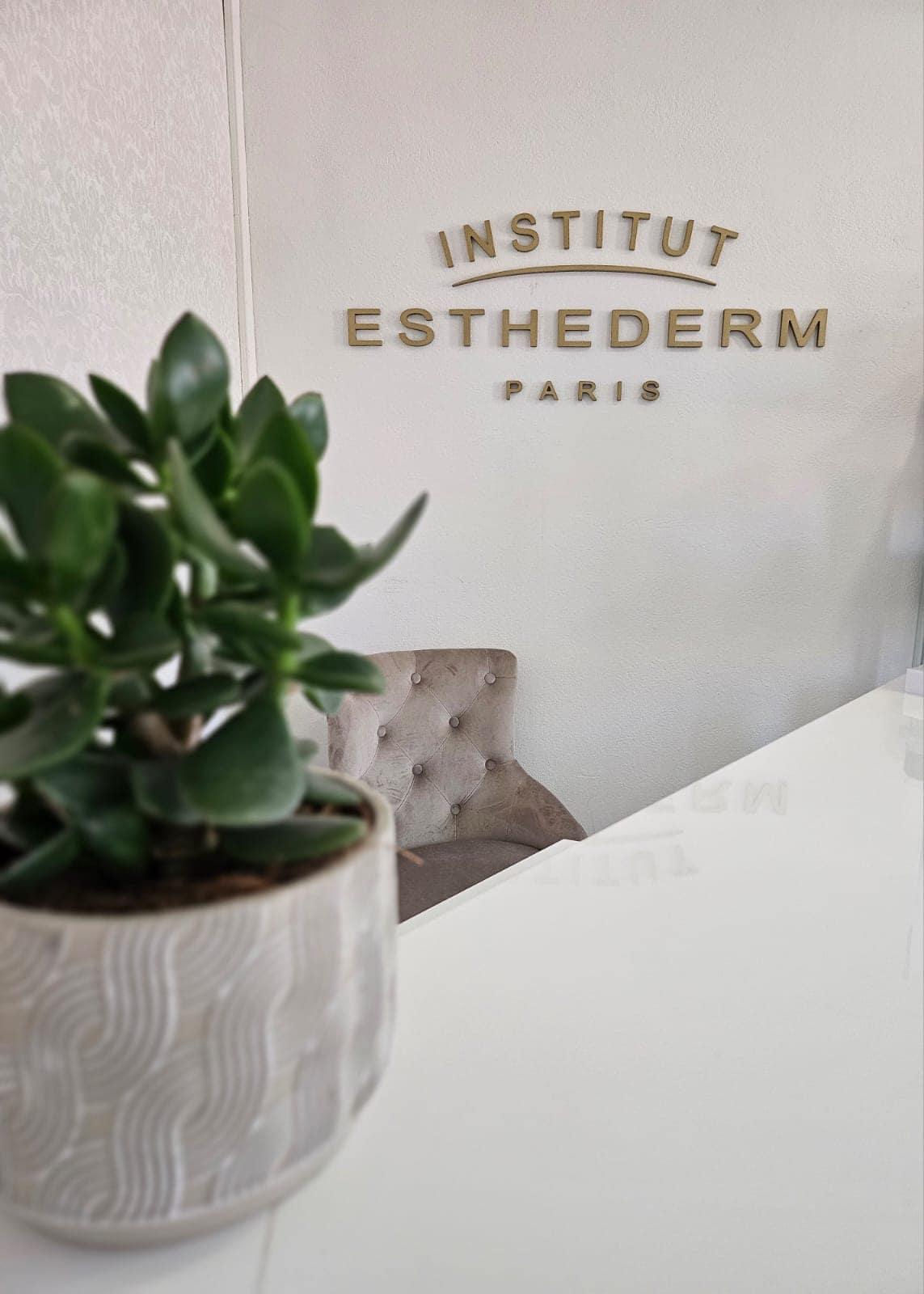 Recepcia Estetického štúdia Spring so zlatým nápisom Institut Esthederm Paris, izbovou rastlinou a zamatovým kreslom.